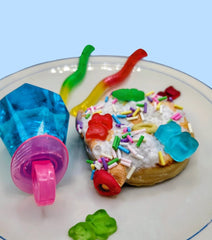 Wall sculpture original ceramic artwork. Donut with colorful icing, sprinkles, and gummy worms on a plate