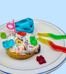 Pop art sculpture. Colorful dessert with gummy worms and jelly beans on a plate