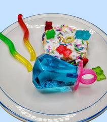 Contemporary art ceramic wall sculpture. Colorful candy on a white plate with a blue background