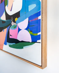 Abstract artwork with colorful geometric shapes in a wooden frame on a white background