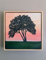 Framed artwork of a tree silhouette against a pink and green landscape.