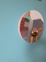 Round painting of a cityscape with a blue background