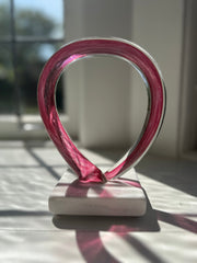 Decorative object with pink on a white base. Glass art sculpture