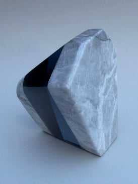 Geometric stone sculpture on a light gray background
