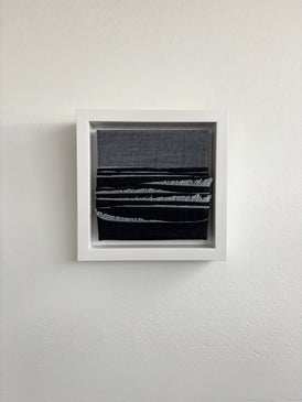 Framed abstract artwork upcycled denim sustainable art oceanscape on a white wall
