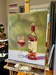 Painting of a bottle and glass of red wine on an easel.