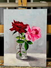 Painting of two roses in a glass jar on an easel.