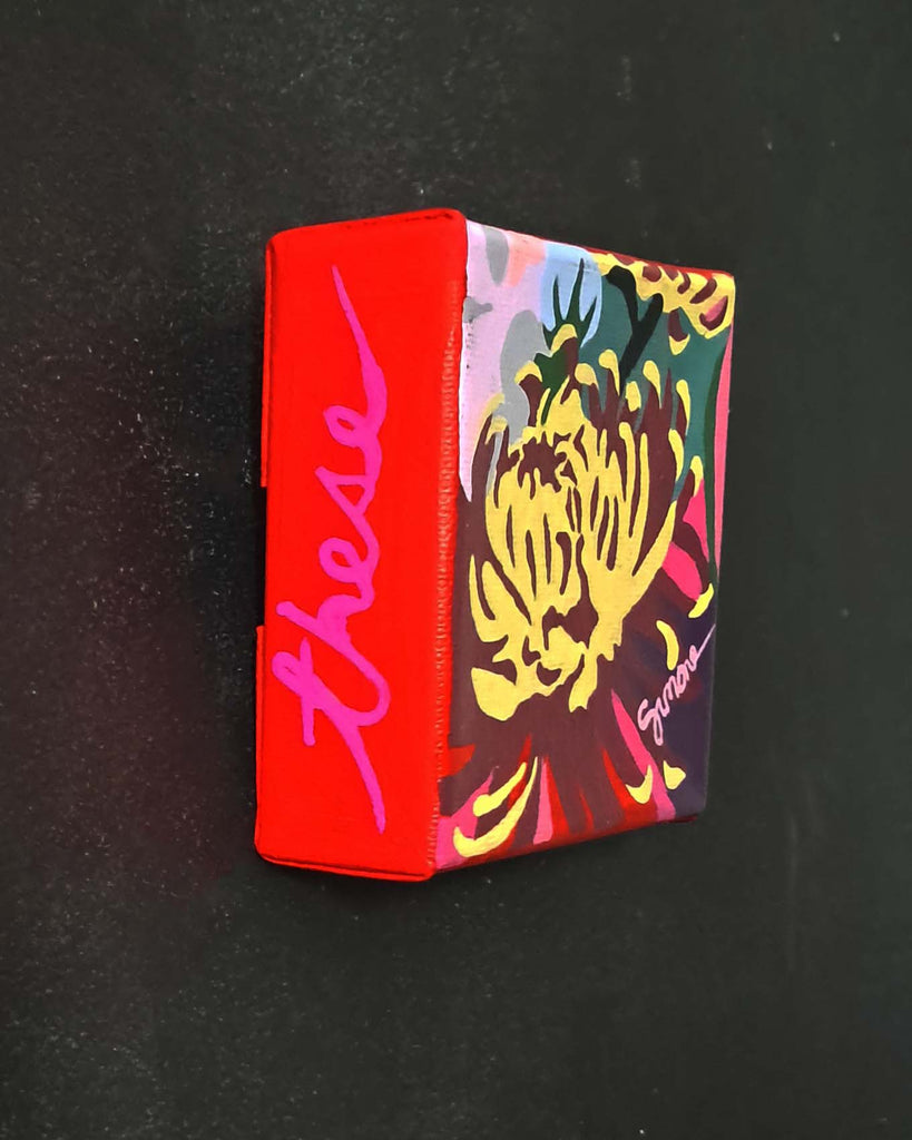 Colorful painting with a floral design and red border on a black background