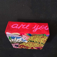 Colorful floral painting with text on a black background