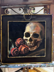 Framed artwork of a skull and roses on a dark background