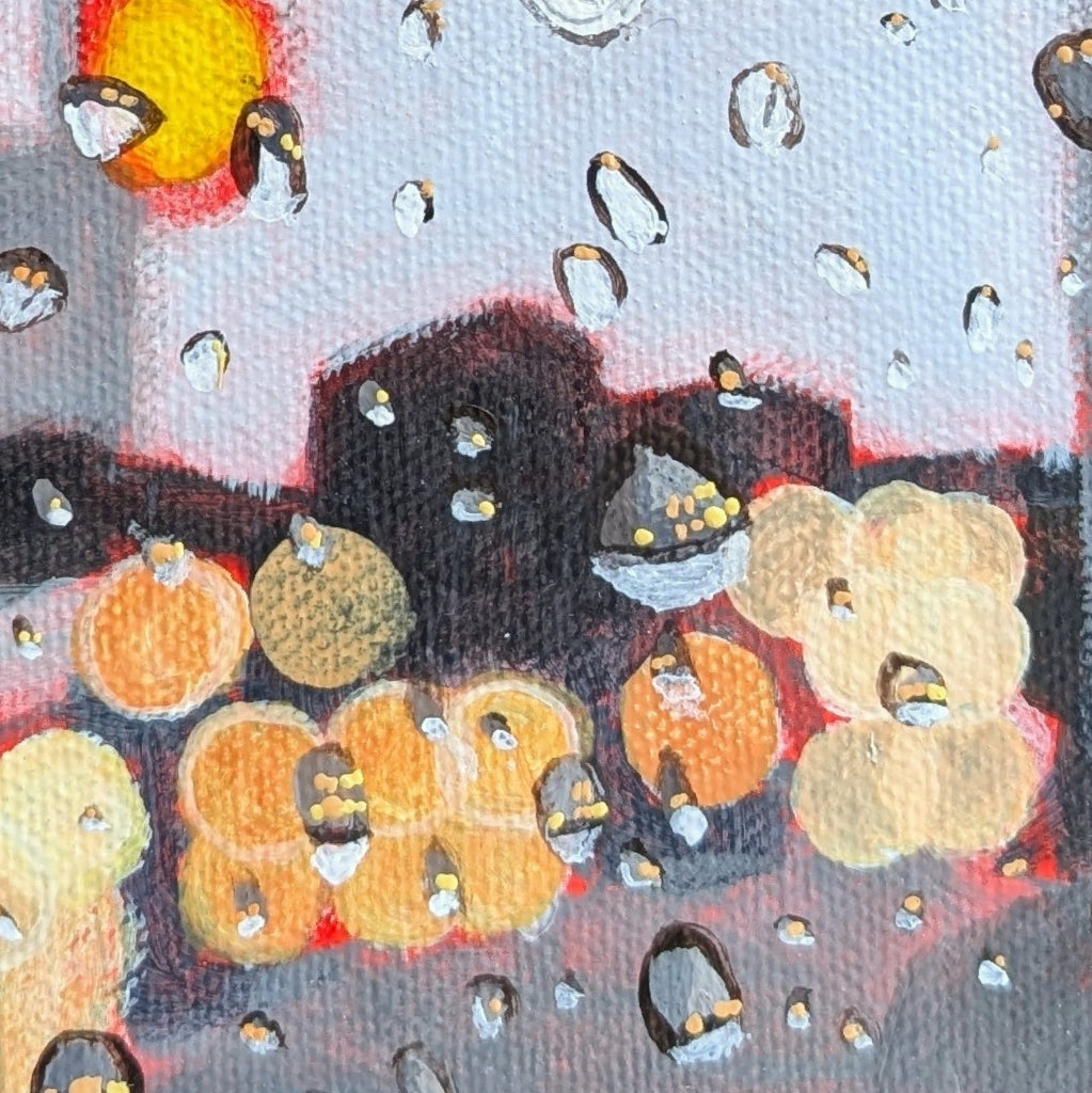 Close-up of an abstract painting with glowing orange and yellow circles, dark black shapes, and scattered reflective droplets on a pale background.