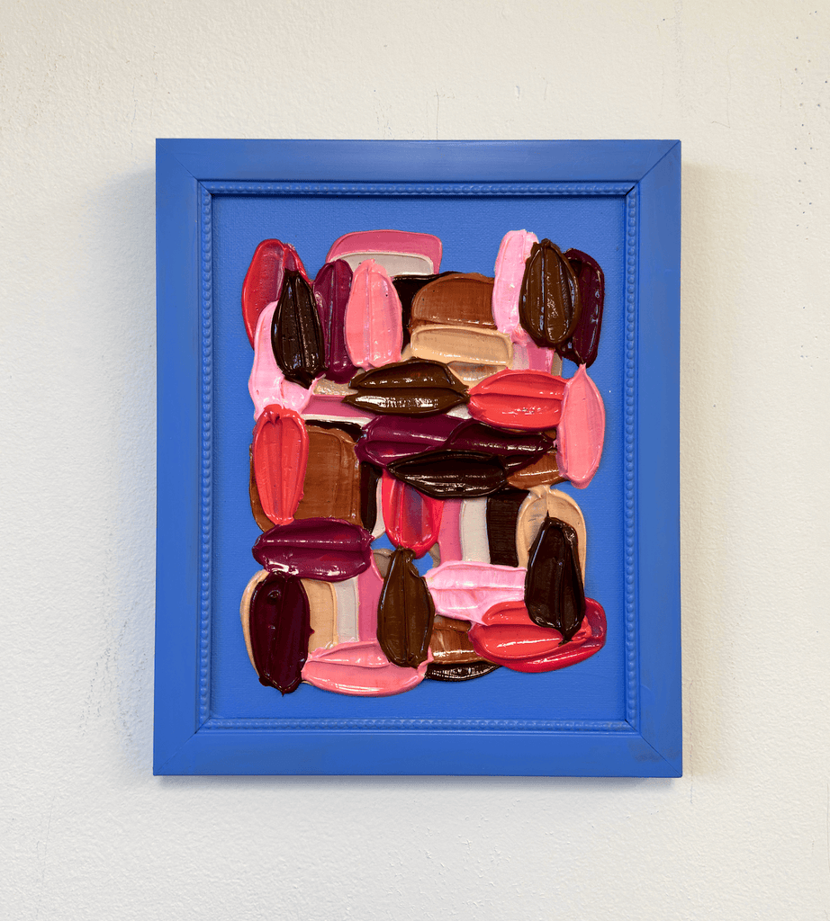 Framed abstract art with colorful impasto brushstrokes on a white wall