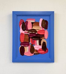 Framed abstract art with colorful impasto brushstrokes on a white wall