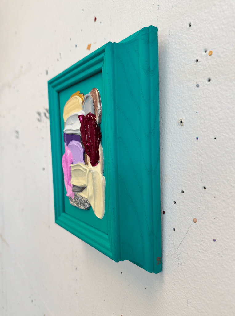 Colorful original acrylic painting in a teal frame on a textured white wall