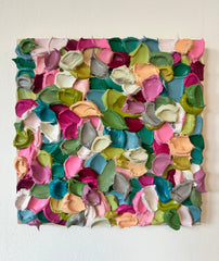 Colorful textured wall art piece on a white wall