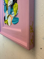 Decorative wall art with colorful brushstrokes on a pink background
