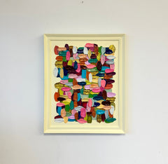 Framed abstract art with colorful geometric shapes on a white wall