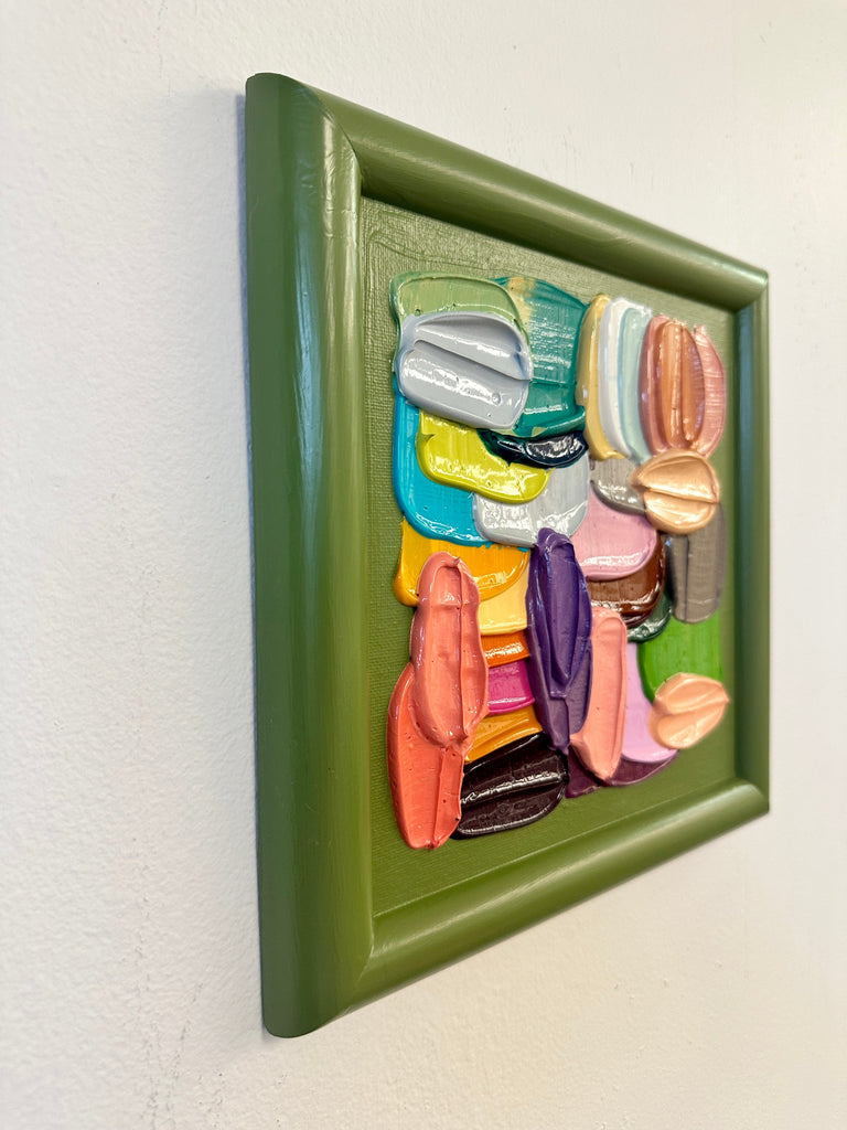 Colorful abstract brushstrokes in a green framed painting