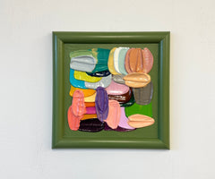 Framed artwork of colorful textured brushstrokes on a white wall