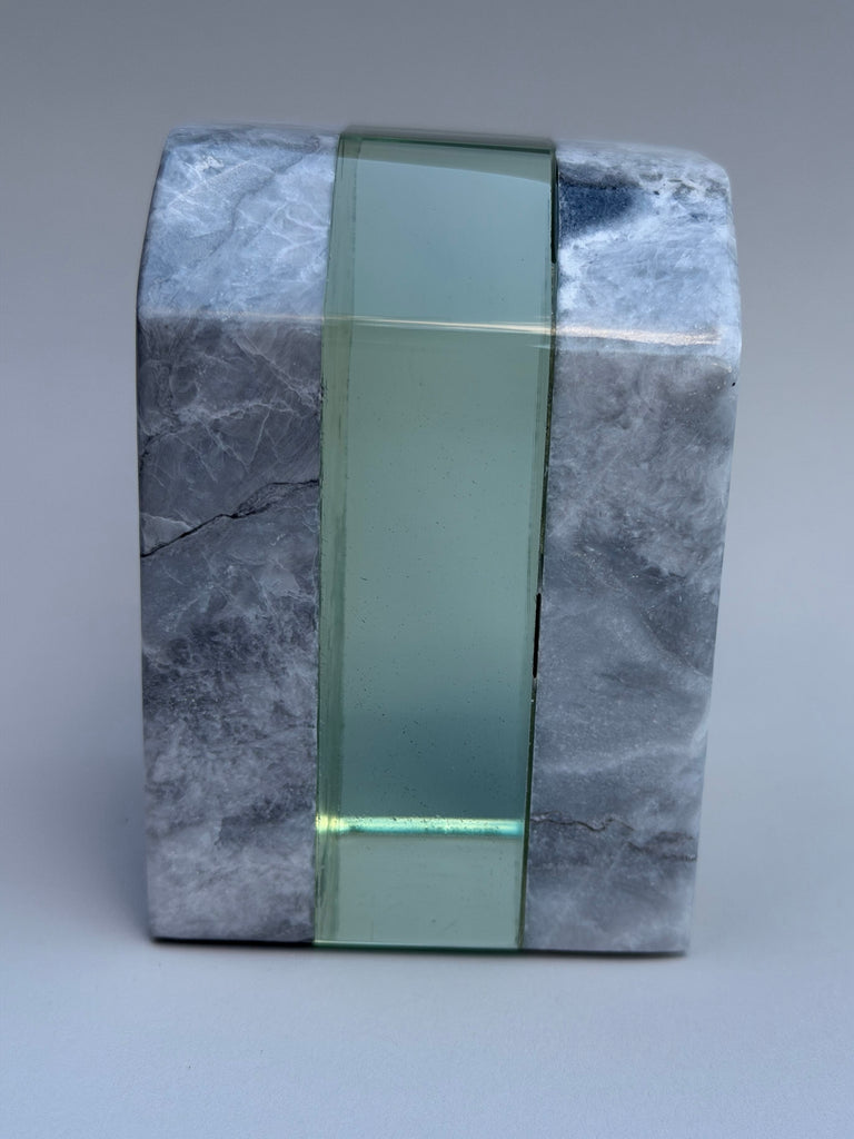 Marble block with a green glass strip on a gray background