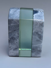 Marble block with a green glass strip on a gray background