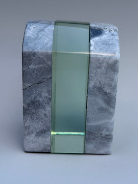 Marble block with a green glass strip on a gray background
