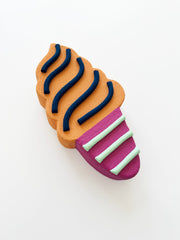 Ice cream cone-shaped pop art sculpture with orange, blue, and pink on a white background
