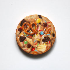 Cookie oil painting with pretzel, chocolate chips, and colorful sprinkles on a white background