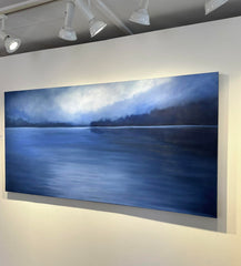 Large painting of a lake scene with trees on a white wall in a gallery setting. Buy affordable art online